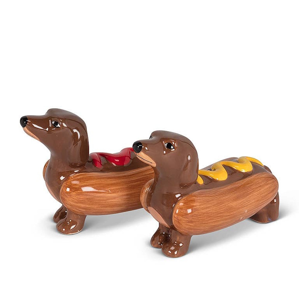 Ceramic dachshund salt and pepper shakers styled as hot dogs with ketchup and mustard on white background.