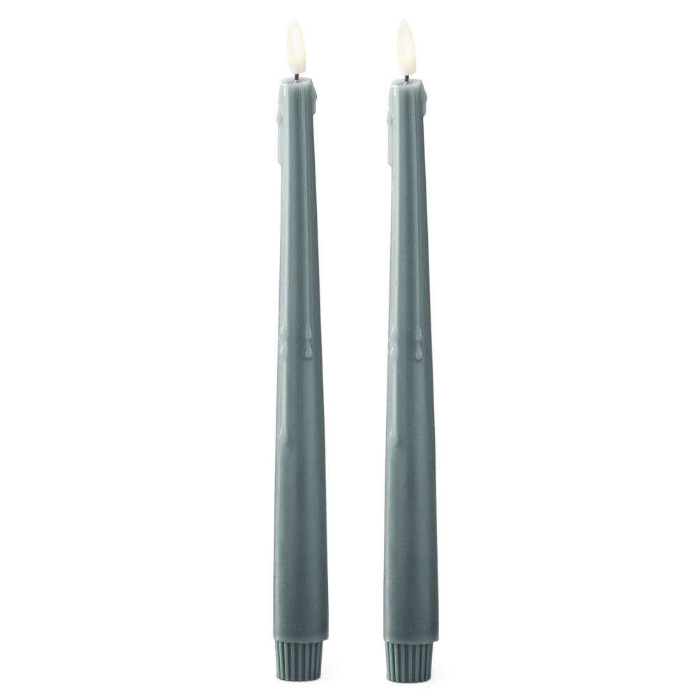 Pair of tall dark green drip-effect LED taper candles with glowing faux flames against a white background.