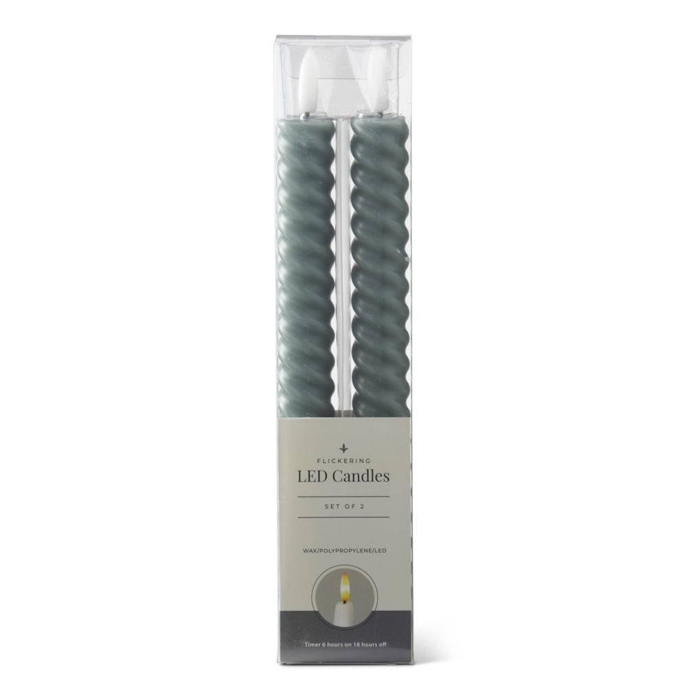 A set of two dark green spiral LED taper candles in clear plastic and cardboard packaging.