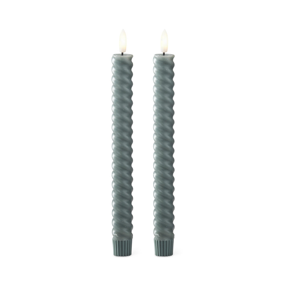 Two dark green spiral LED taper candles with glowing faux flames, standing upright on a white background.