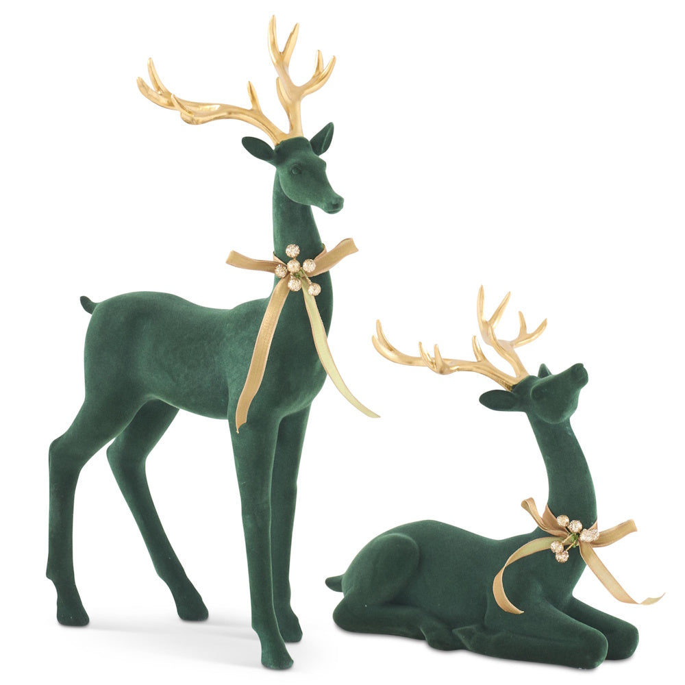Front view of two dark green velvet deer figurines with gold antlers and bows.
