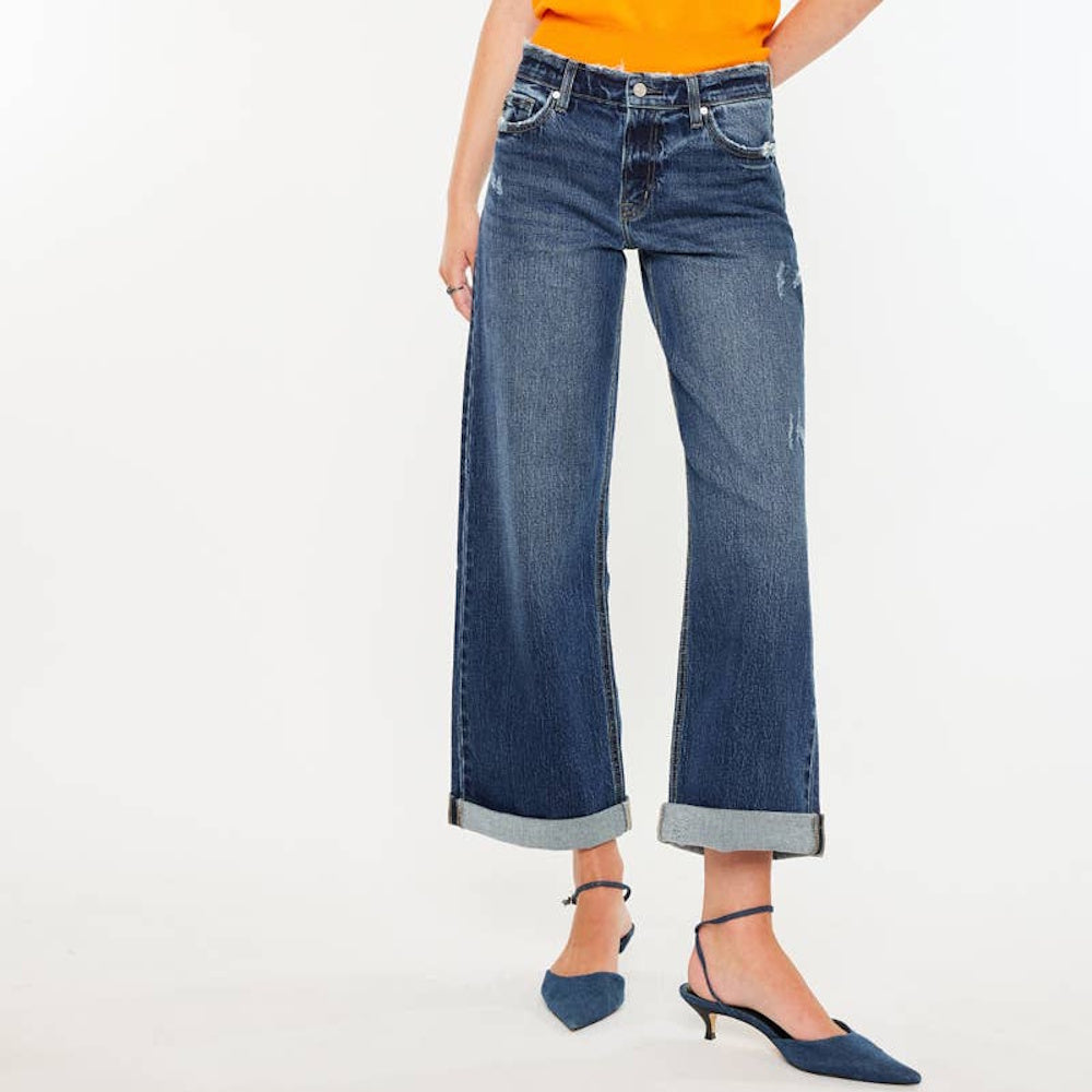Front view of high-rise wide-leg blue jeans featuring wide cuffed hems and light distressing.