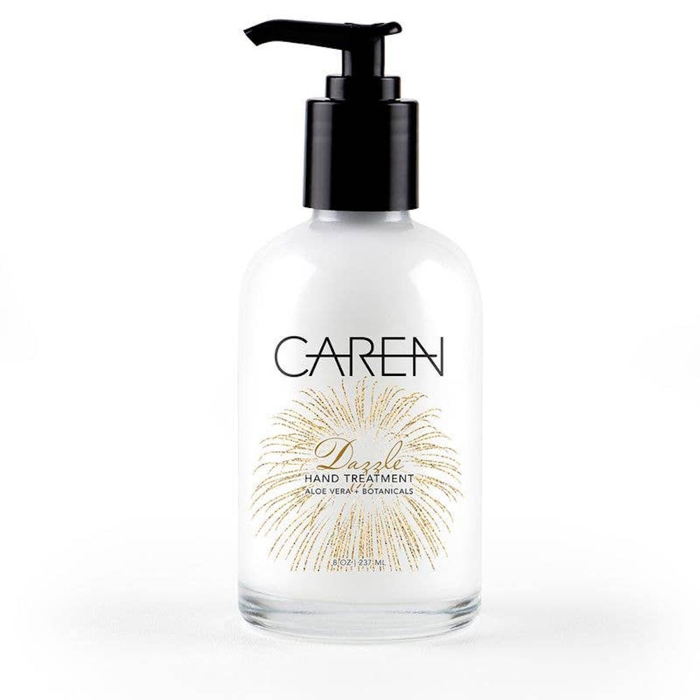 A clear glass bottle of Caren Dazzle hand treatment with a black pump and a gold firework design.