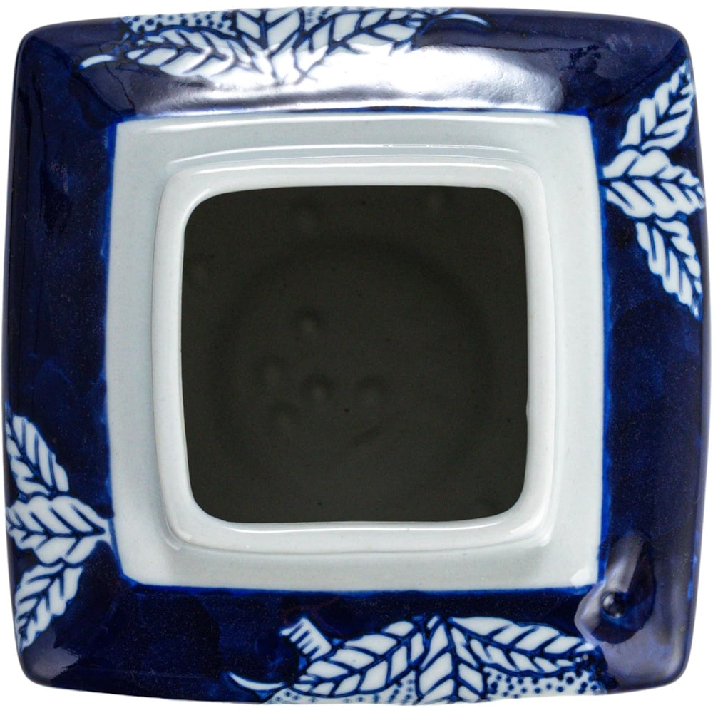 Top-down view of a square, blue and white ceramic vessel with a leaf-patterned border and empty interior.