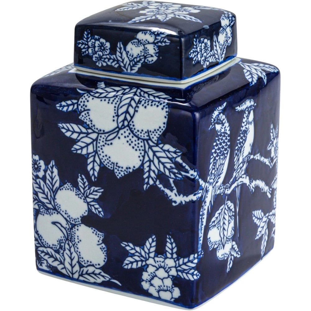 Square blue and white ceramic ginger jar with a lid, featuring patterns of birds, fruit, and flowers.