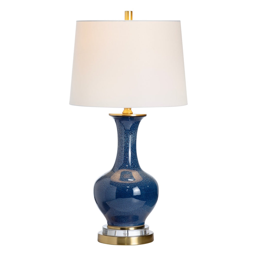 Navy blue glazed ceramic table lamp with gold accents and a white drum shade for modern living room decor.