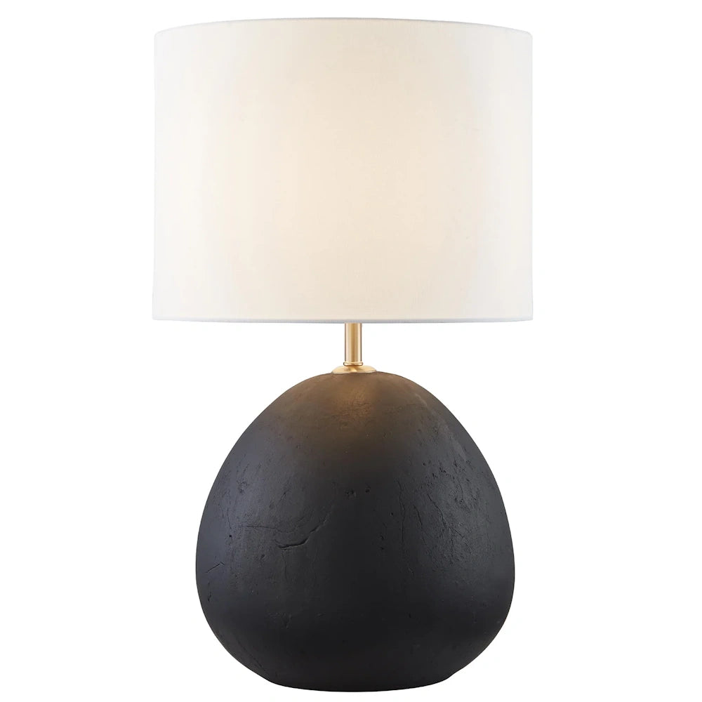 Modern black textured stone table lamp with a round base, gold neck, and white drum fabric lampshade.