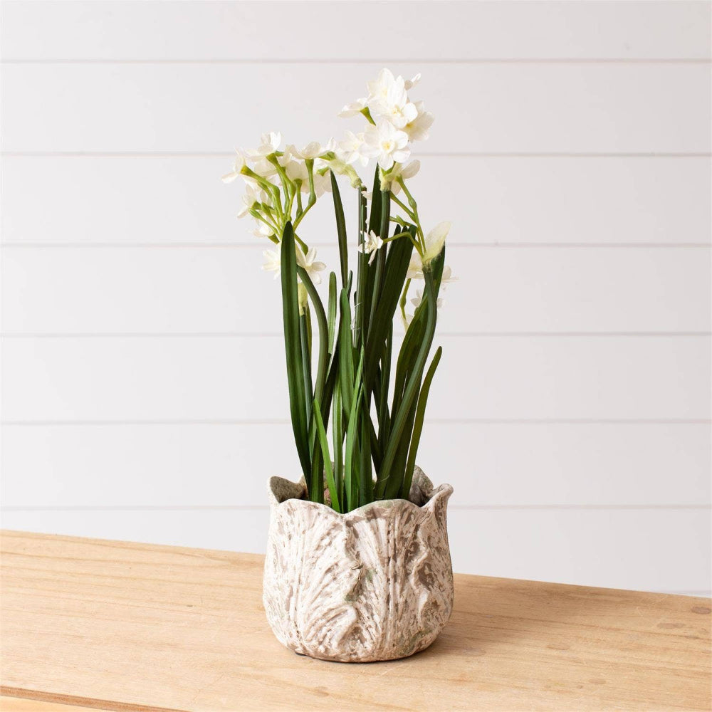Distressed white leaf design ceramic planter with white faux flowers on a wooden table, farmhouse style home decor.