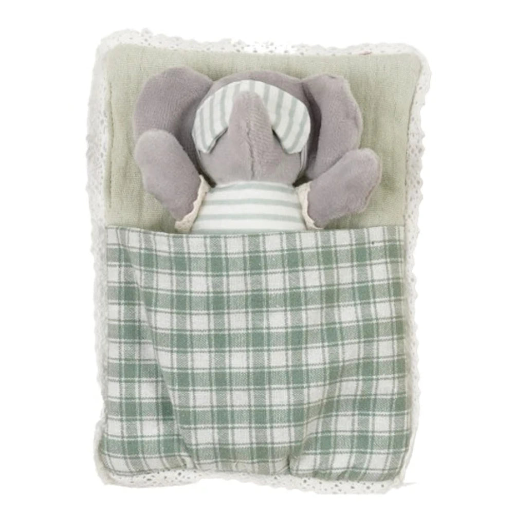Small plush elephant wearing a striped eye mask sleeping in a green plaid sleeping bag with lace trim.
