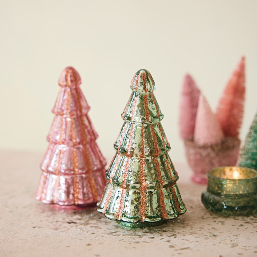 Pink and green mercury glass tree decorations with copper glitter stripes displayed on a surface.