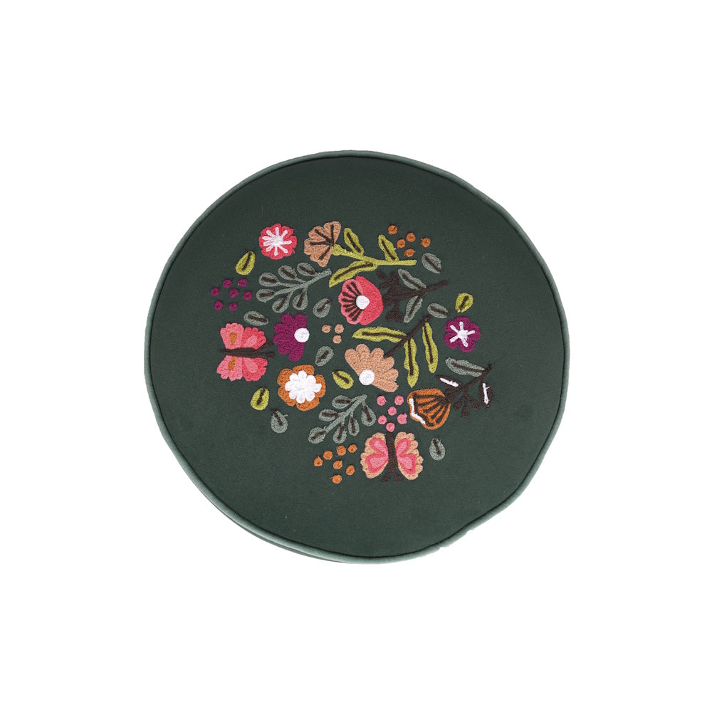 Round dark green throw pillow with embroidered colorful flowers and butterflies.