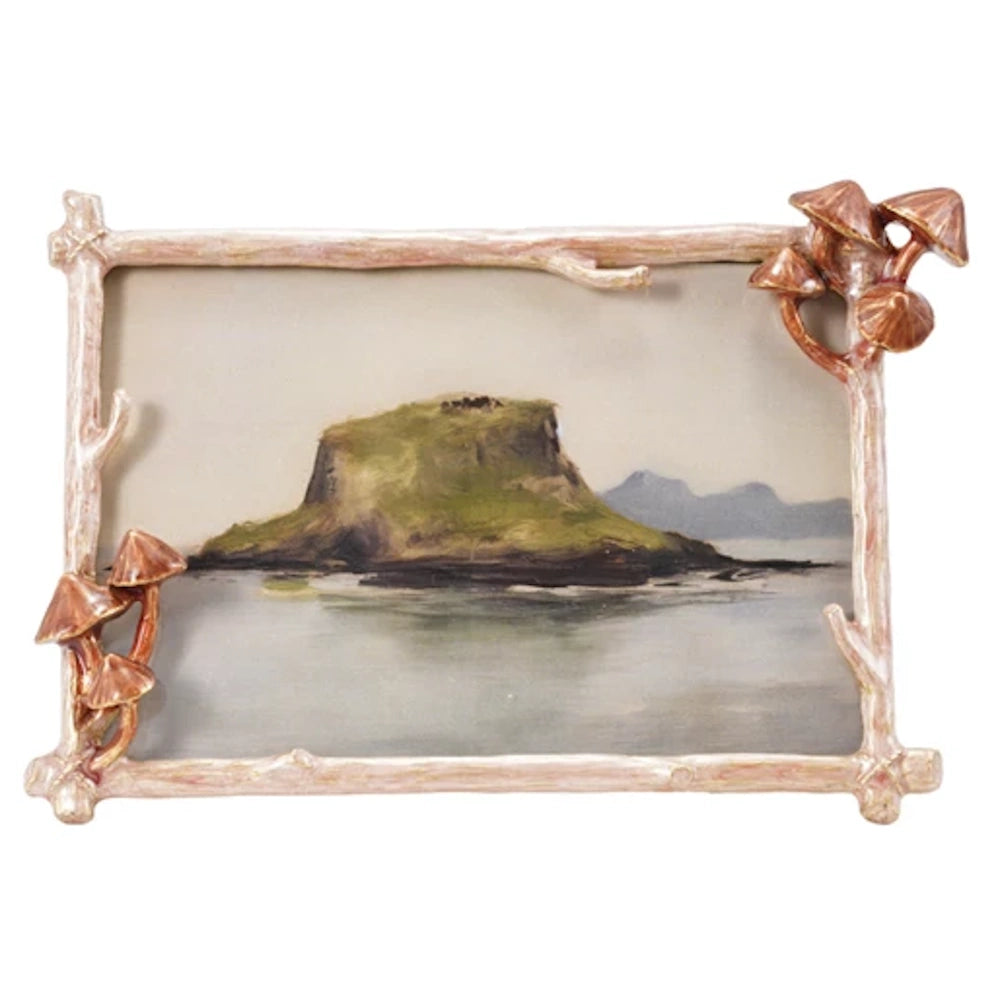 Enameled metal photo frame with 3D mushrooms and twig texture surrounding a landscape painting of a mossy island.