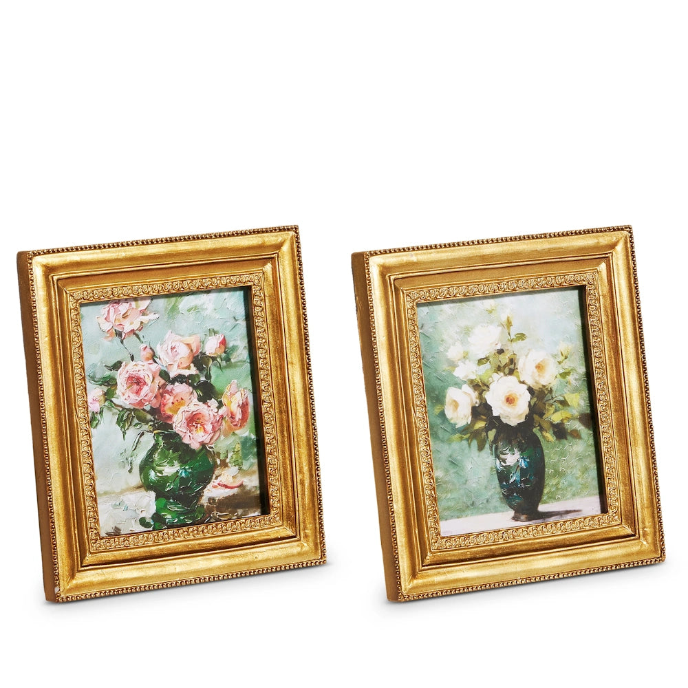 Two elegant gold-framed paintings featuring floral arrangements: one with pink roses and the other with white roses in a vase.