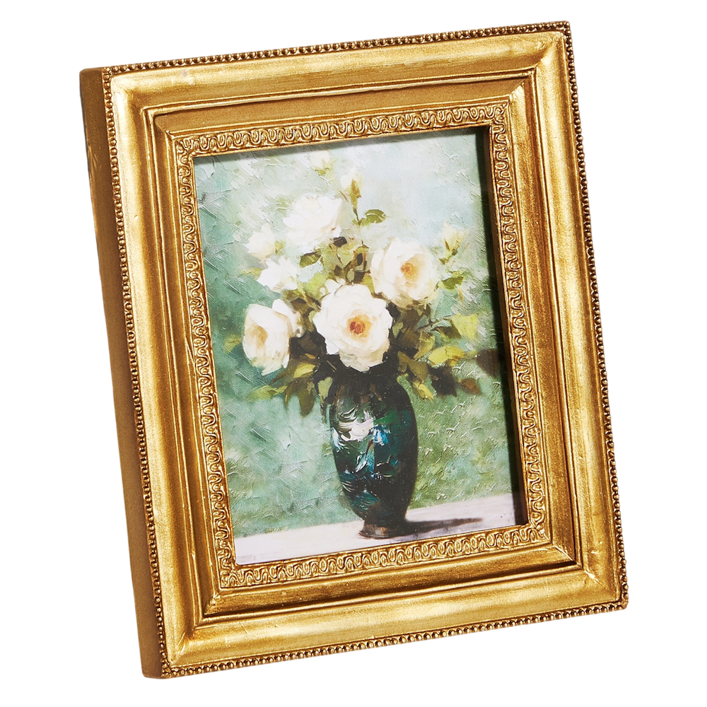 Gold-framed painting of white roses in a teal vase, set against a soft green background.