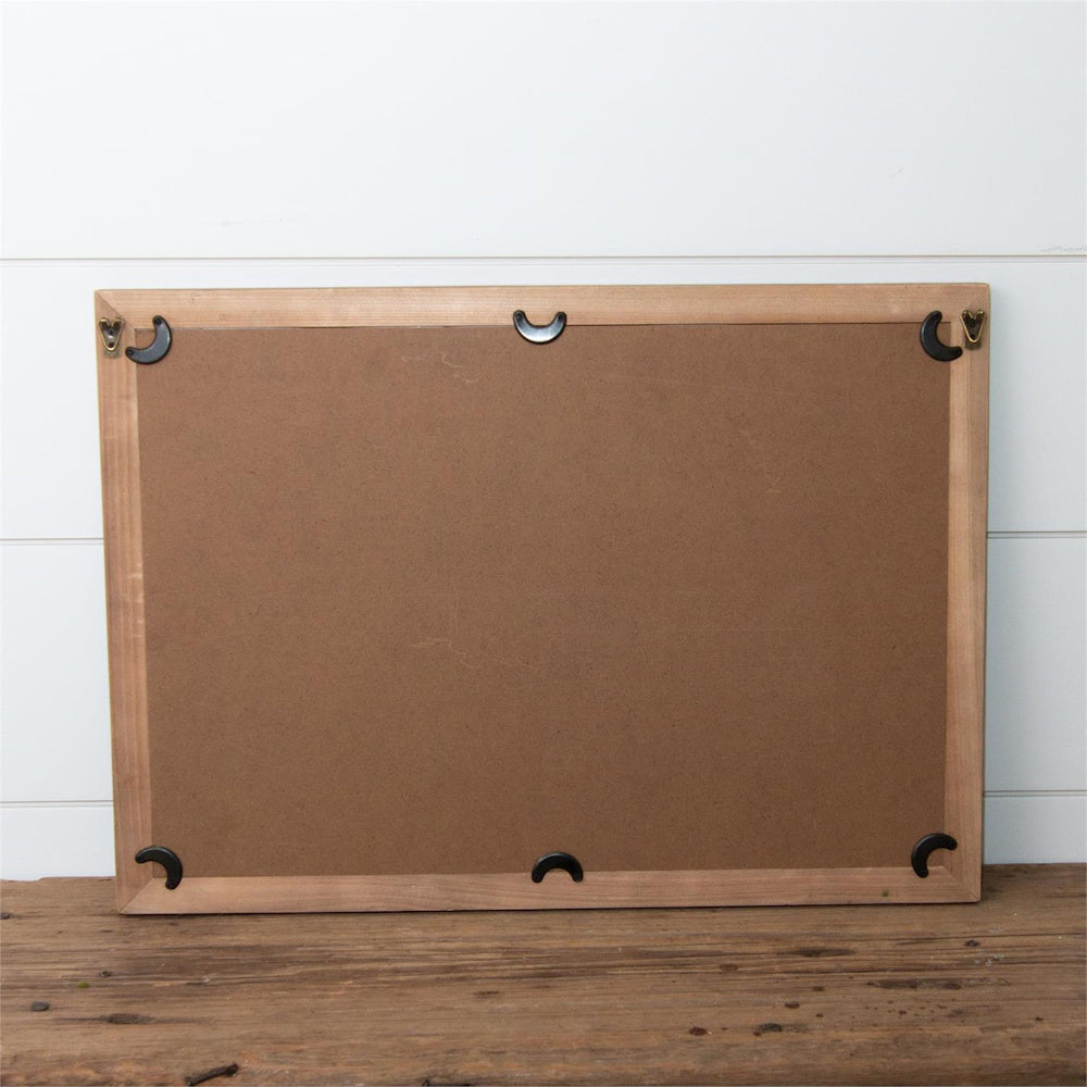 Back view of a wooden picture frame showing the brown backing board, metal turn buttons, and hanging hardware.