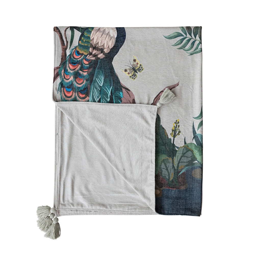 Folded fabric blend chenille throw featuring a peacock, butterfly, and botanical design with corner tassels.