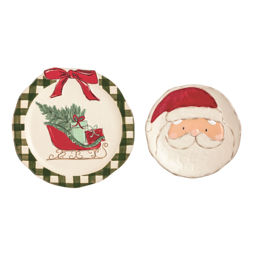 Two Christmas plates: one with a green check rim, red bow, and sleigh, and one shaped like Santa's face.