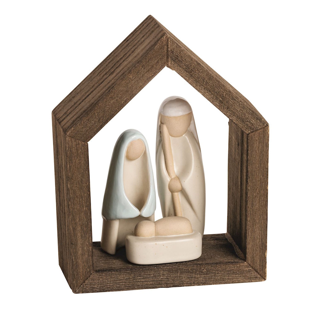 Minimalist ceramic Holy Family Nativity figures set inside a dark wooden house frame.