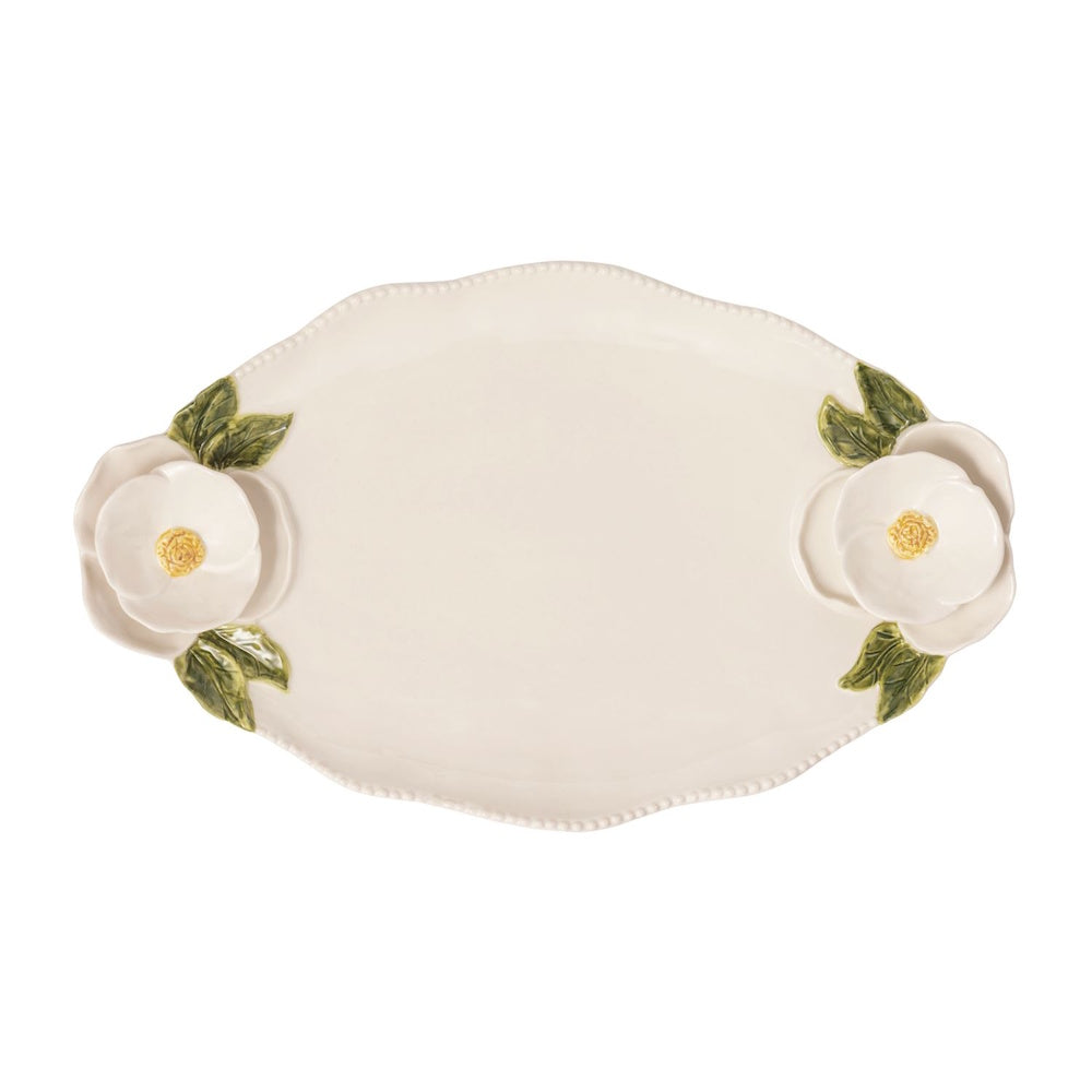 White ceramic oval serving platter with raised white flower and green leaf details on each end, isolated on white.
