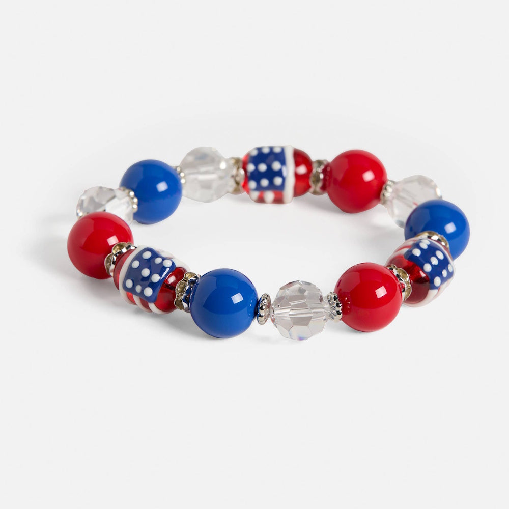 Red, white, and blue American flag beaded bracelet with clear faceted accents and silver spacers on a white background.