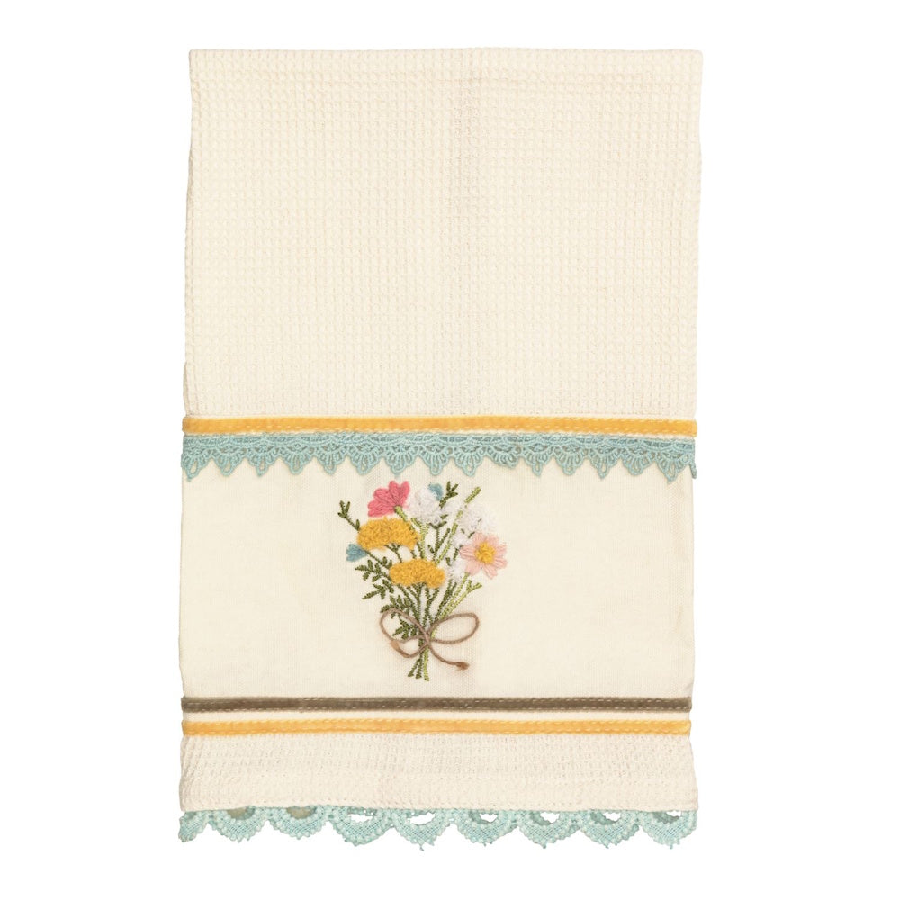 Cream waffle-knit hand towel with embroidered wildflower bouquet, scalloped lace trim, and yellow velvet ribbon accents.