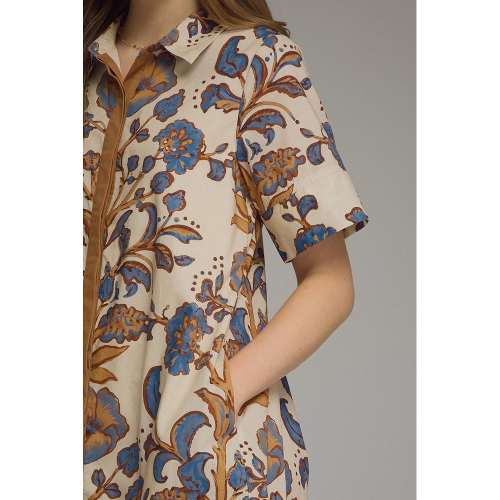 Close-up view of a beige floral shirt dress showing blue and brown floral patterns, side pocket, and collar detail.