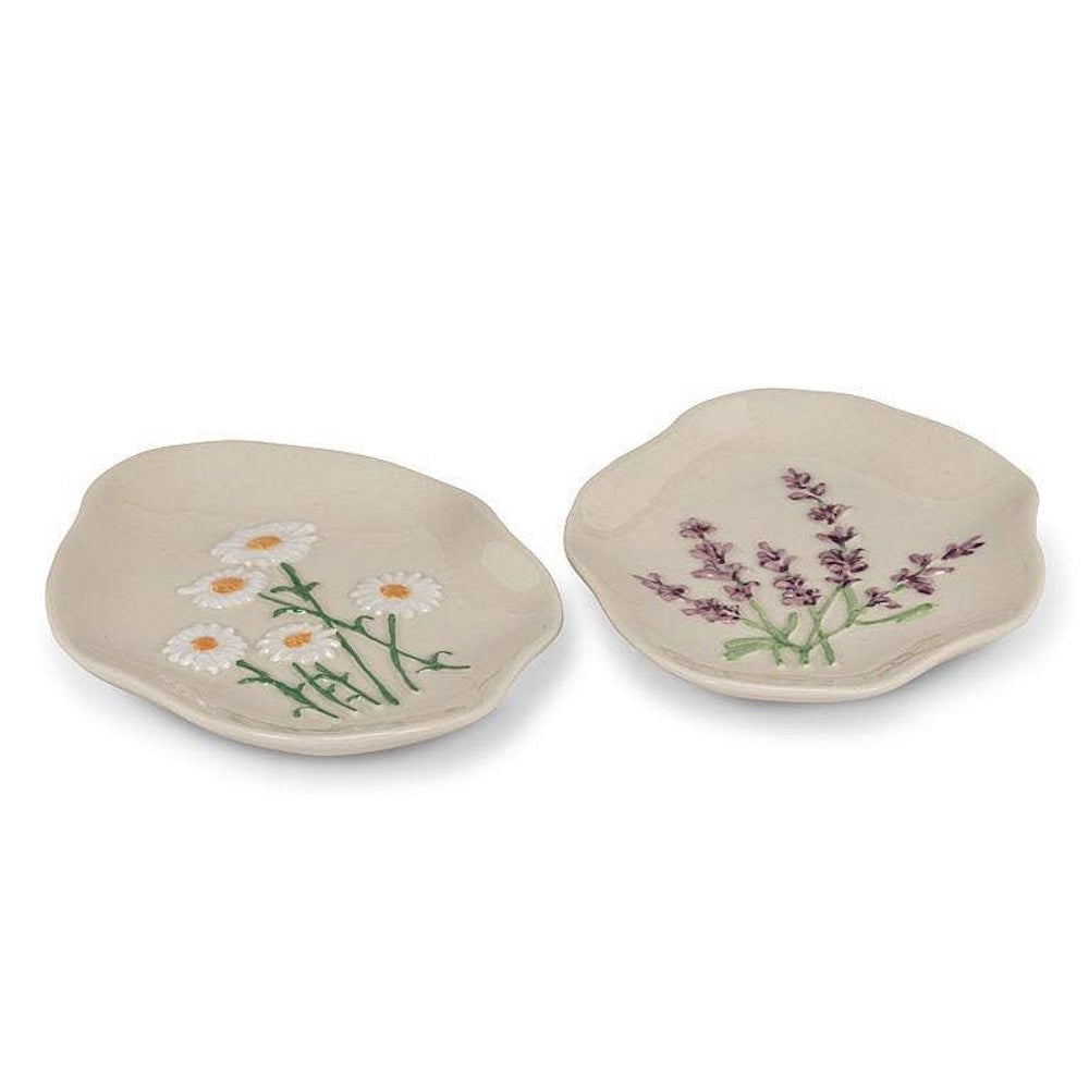 Two organic-shaped ceramic dishes with raised floral designs of white daisies and purple lavender.