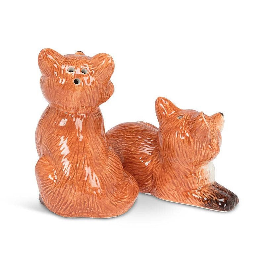 Ceramic orange fox salt and pepper shakers shown from behind, one sitting and one lying down.