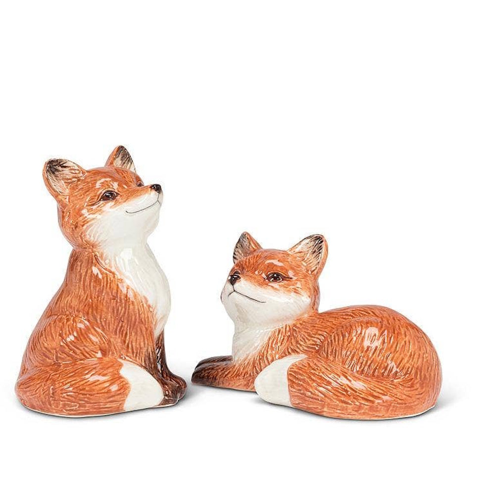 Pair of ceramic orange fox salt and pepper shakers, one sitting upright and one lying down.