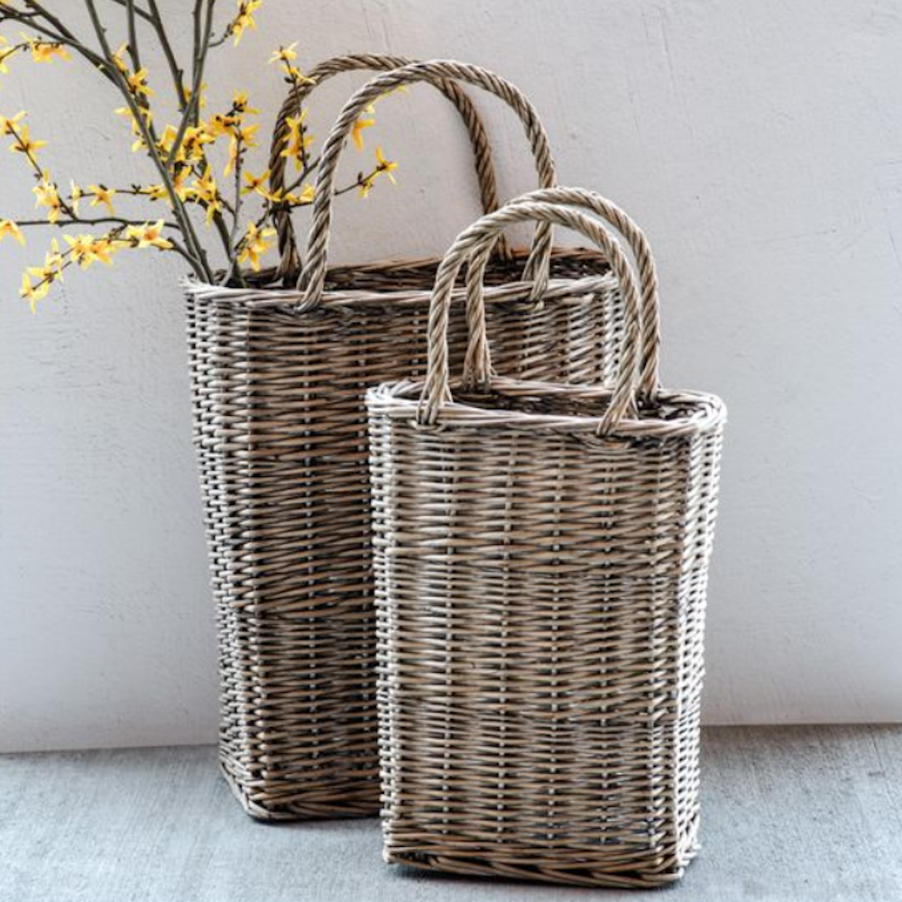 Set of two tall french woven willow flower baskets with handles, one featuring yellow floral branches.