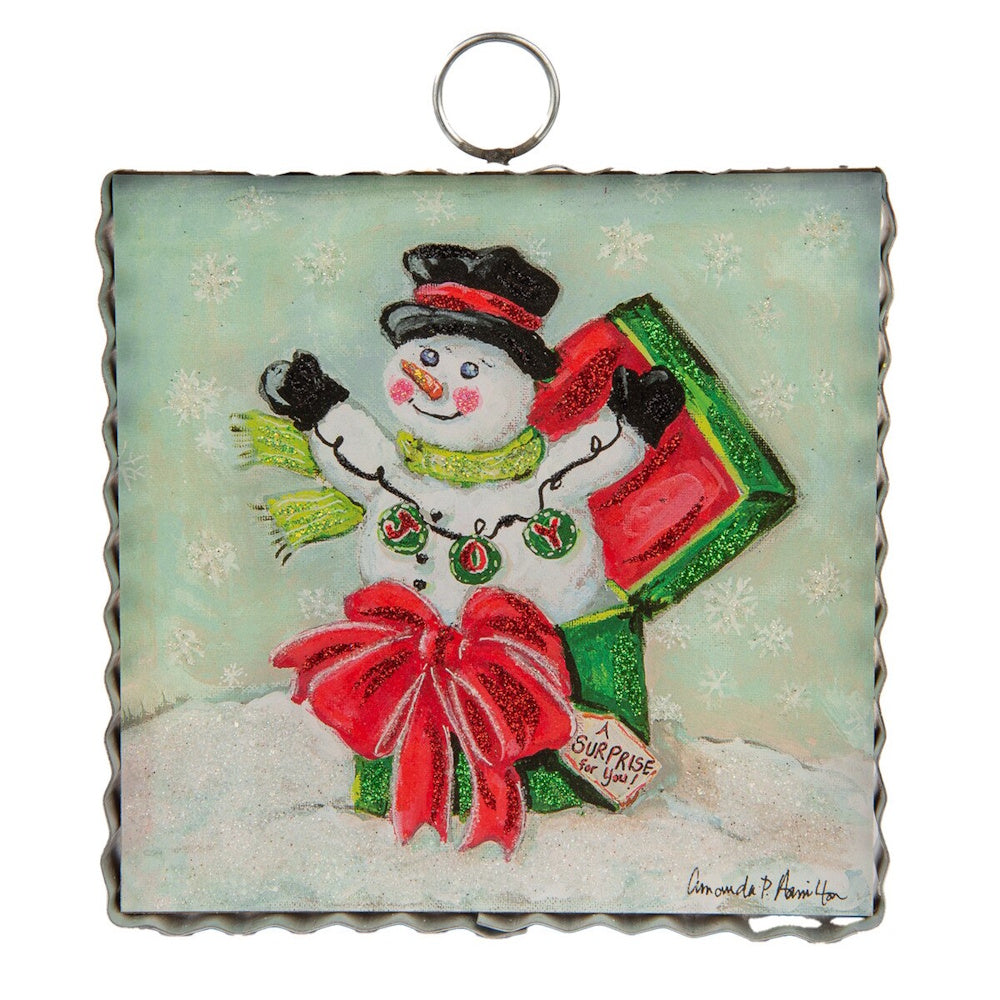 Front view of a square metal snowman art piece with a black hat, red bow, and green gift box.
