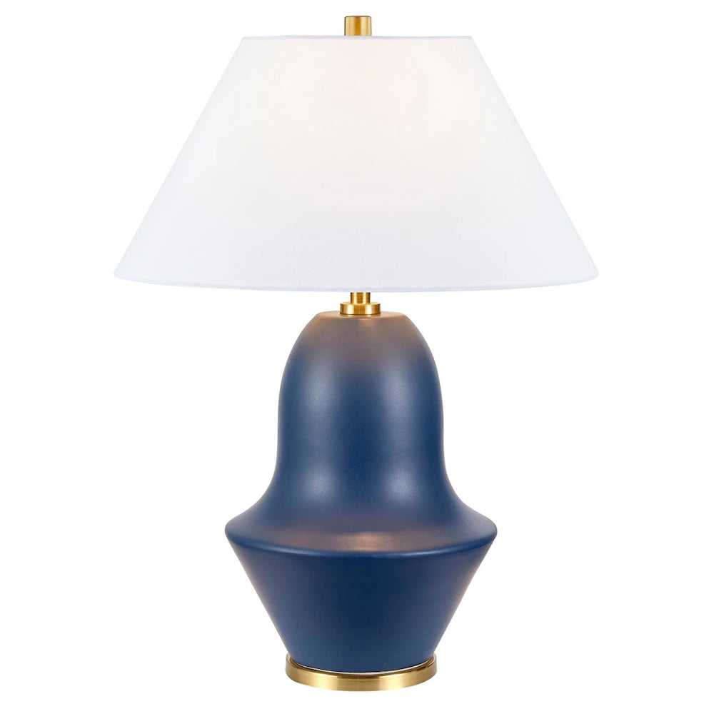 Modern navy blue ceramic table lamp with a white tapered fabric shade and gold brass accents for home decor.