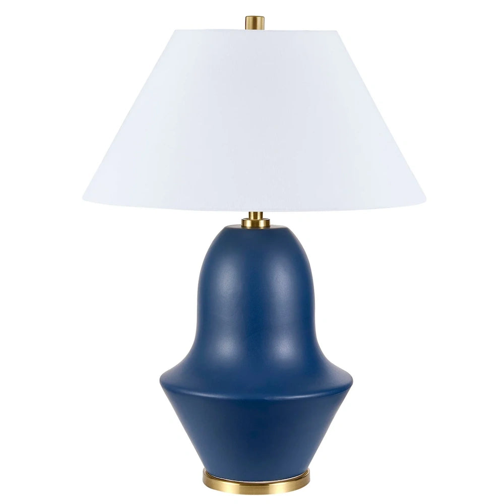 Modern navy blue ceramic table lamp with a white tapered fabric shade and gold brass accents for home decor.