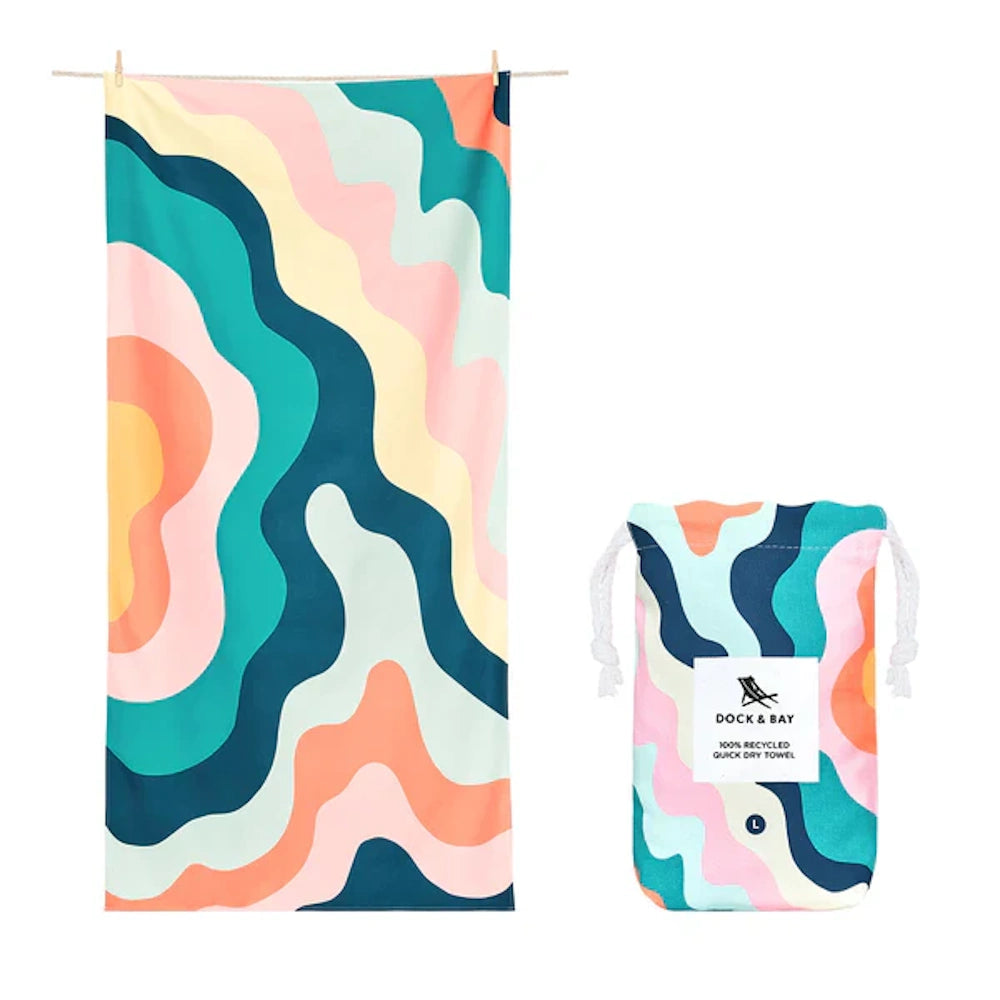 Colorful beach towel with wavy patterns hanging next to a matching drawstring pouch.