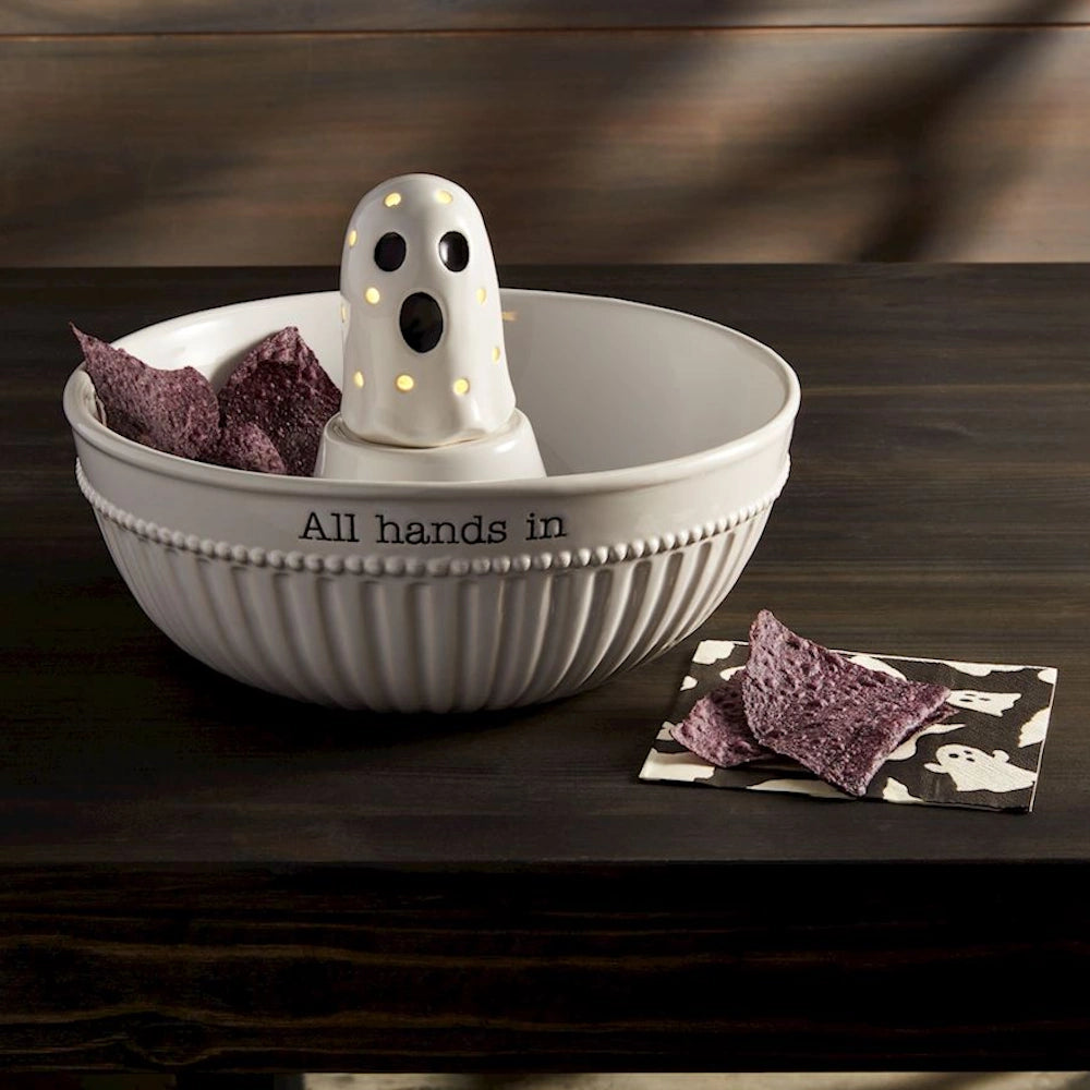 Halloween ghost light-up chip bowl with purple tortilla chips on a dark wooden table background.