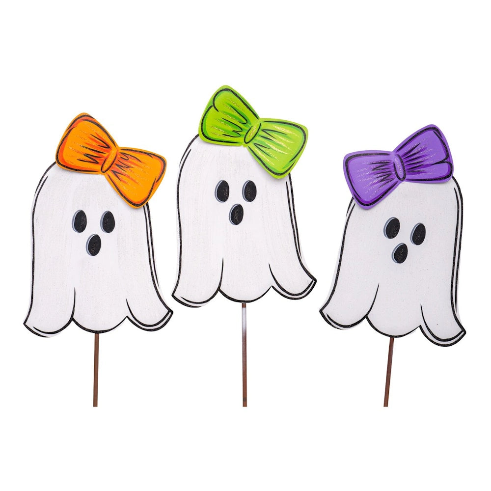 Three friendly white ghost Halloween yard stakes wearing orange, green, and purple hair bows.