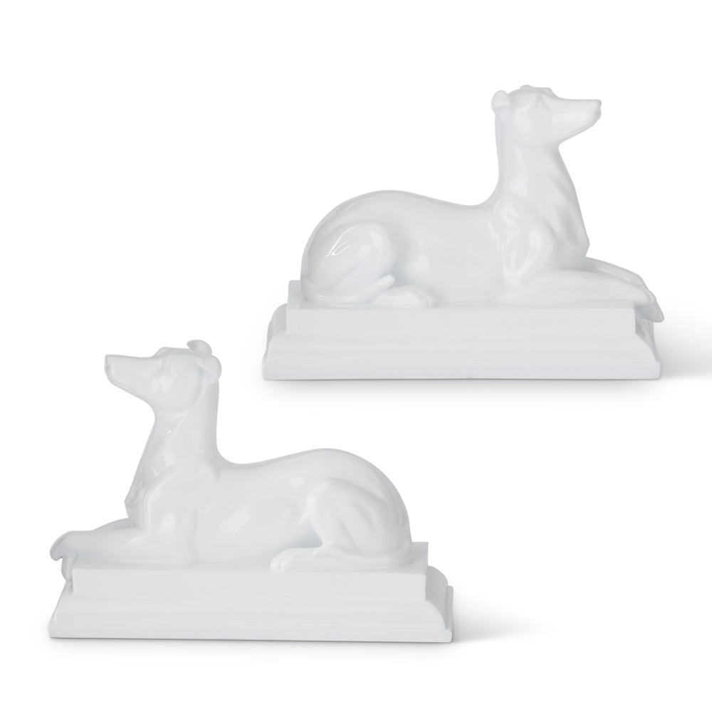 Two glossy white enameled resin dog statues in a reclining position, SEO-optimized for home decor.