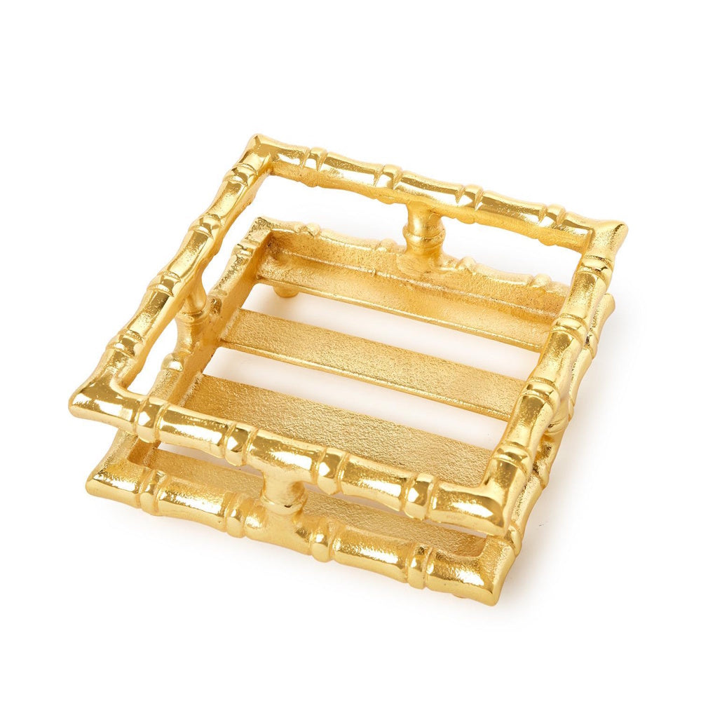 Square gold cocktail napkin holder with a faux bamboo design and slatted base on a white background.