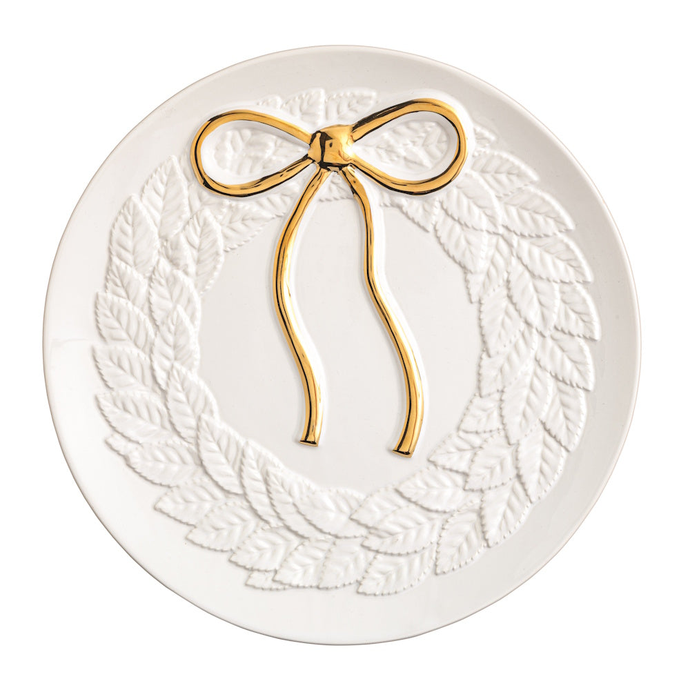 White holiday cookie plate featuring an embossed wreath and a gold bow.