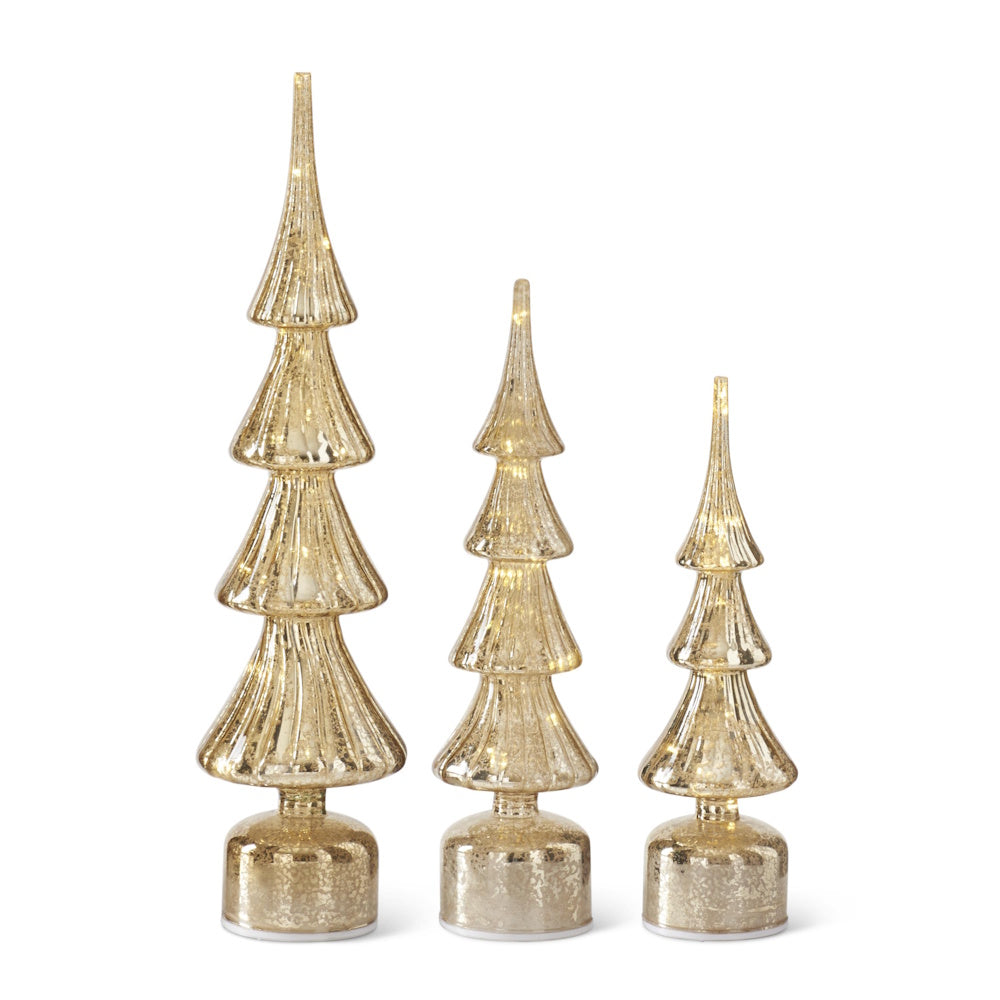 Set of three illuminated gold mercury glass Christmas tree decorations in varying heights on a white background.