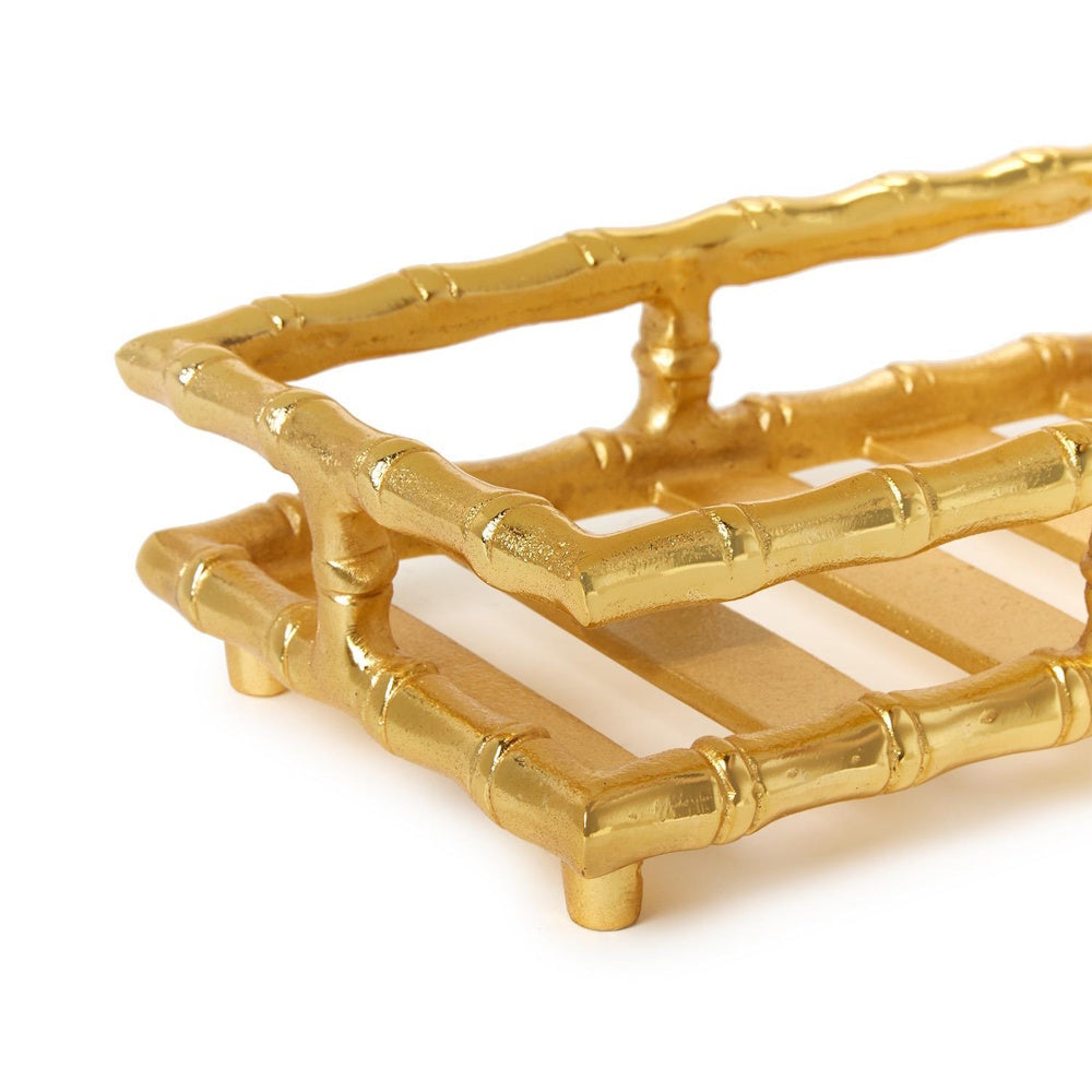 Close-up of a gold metal napkin holder featuring a textured bamboo-style frame on a white background.