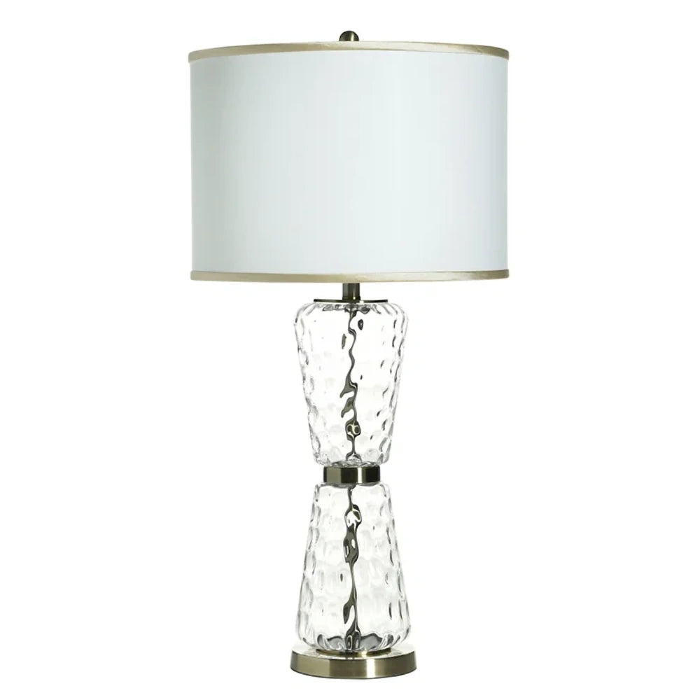 Modern glass table lamp with textured clear base and white drum shade.