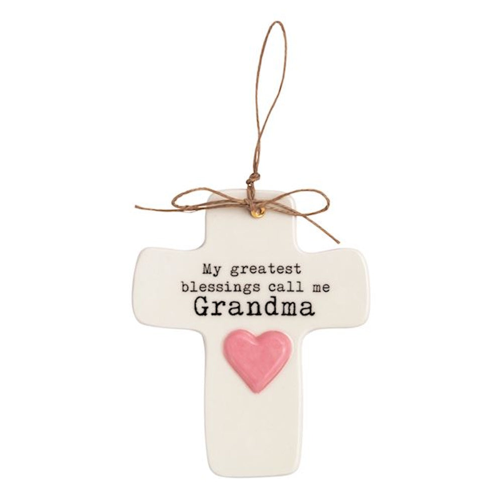 White ceramic cross ornament with pink heart and "My greatest blessings call me Grandma" quote.