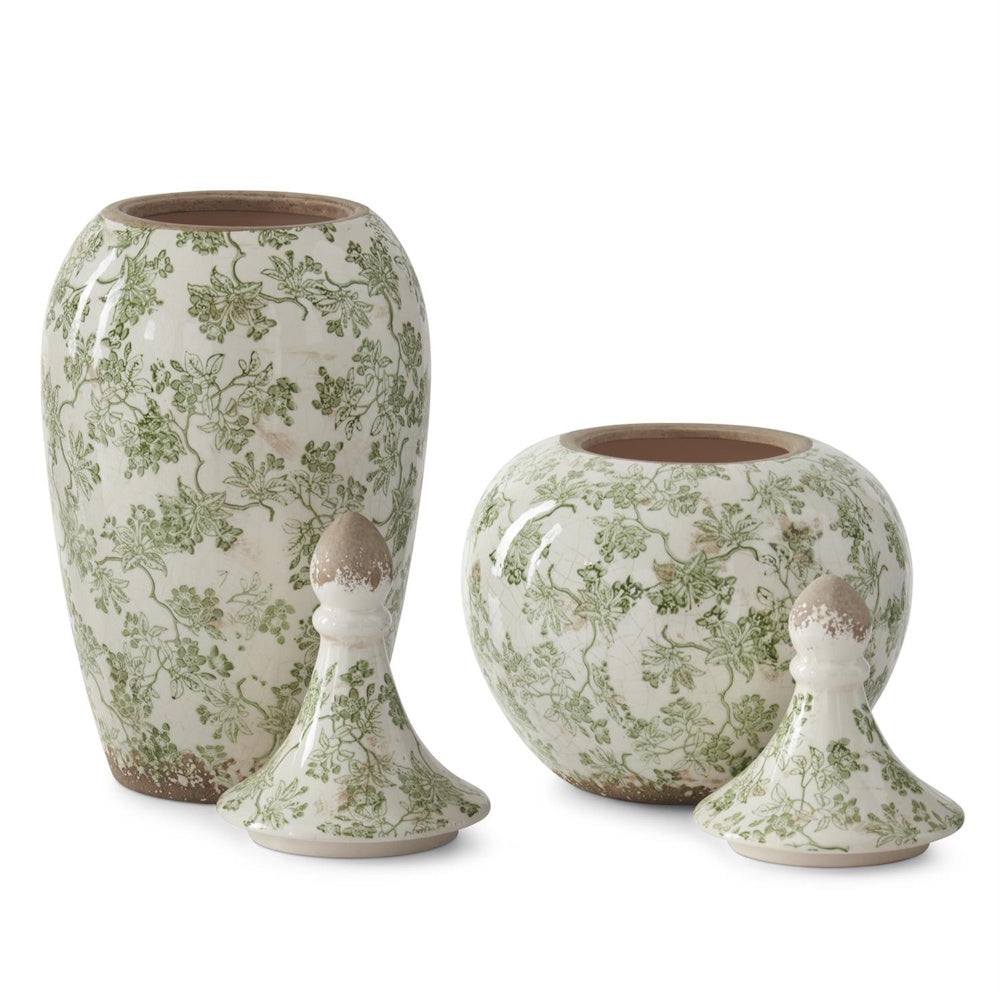 Two green and cream crackled ceramic Chinoiserie ginger jars with floral patterns and matching lids on a white background.