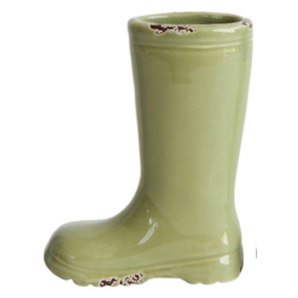 A ceramic vase shaped like a green rain boot with distressed, chipped brown details around the rim and sole.