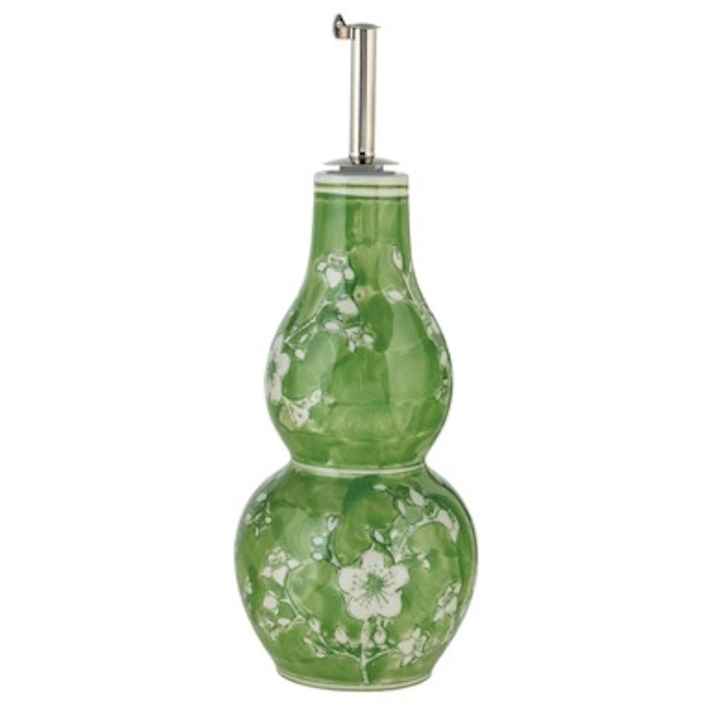 Green hand-painted stoneware oil cruet with white floral patterns and a silver metal pour spout.
