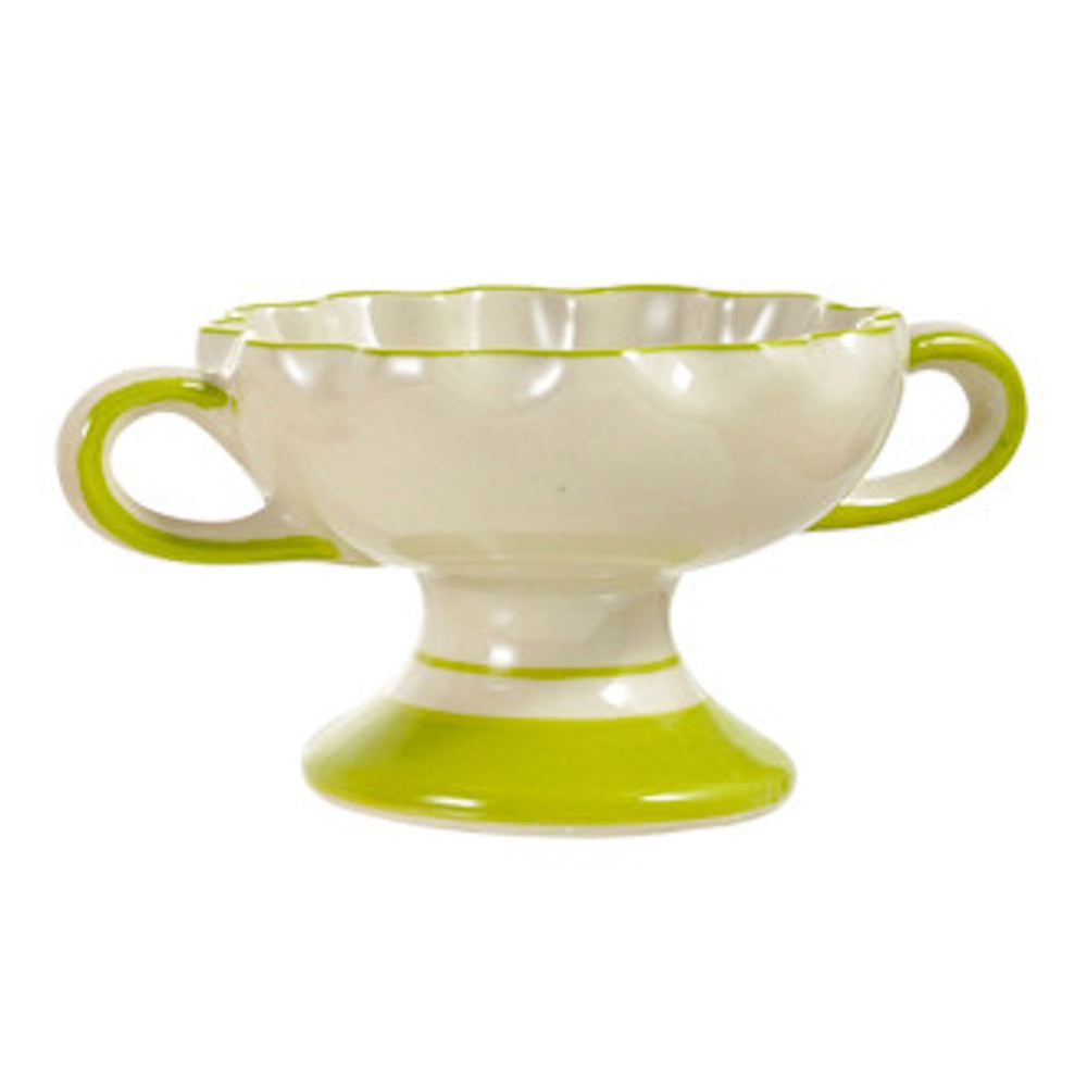 Scalloped ceramic footed bowl in cream with green handles and trim on a white background.
