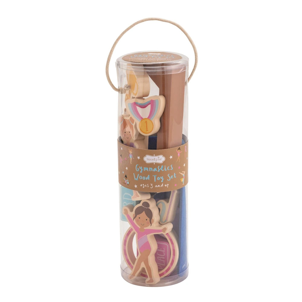 Mud Pie Gymnastics Wood Toy Set in clear tube packaging with wooden gymnast, medal, and balance beam for ages 3 and up.