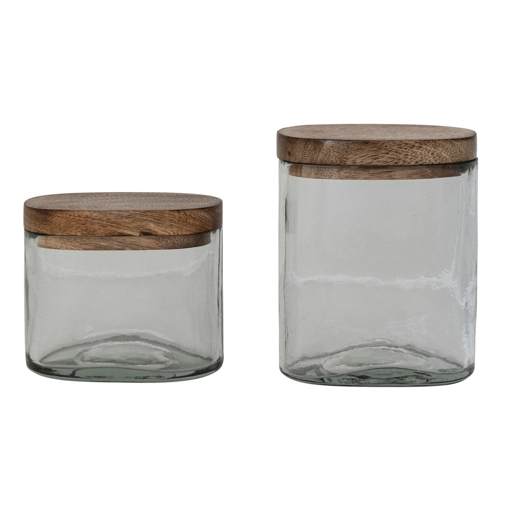 Two hand-blown glass jars with mango wood lids in different sizes, ideal for sustainable kitchen storage and decor.