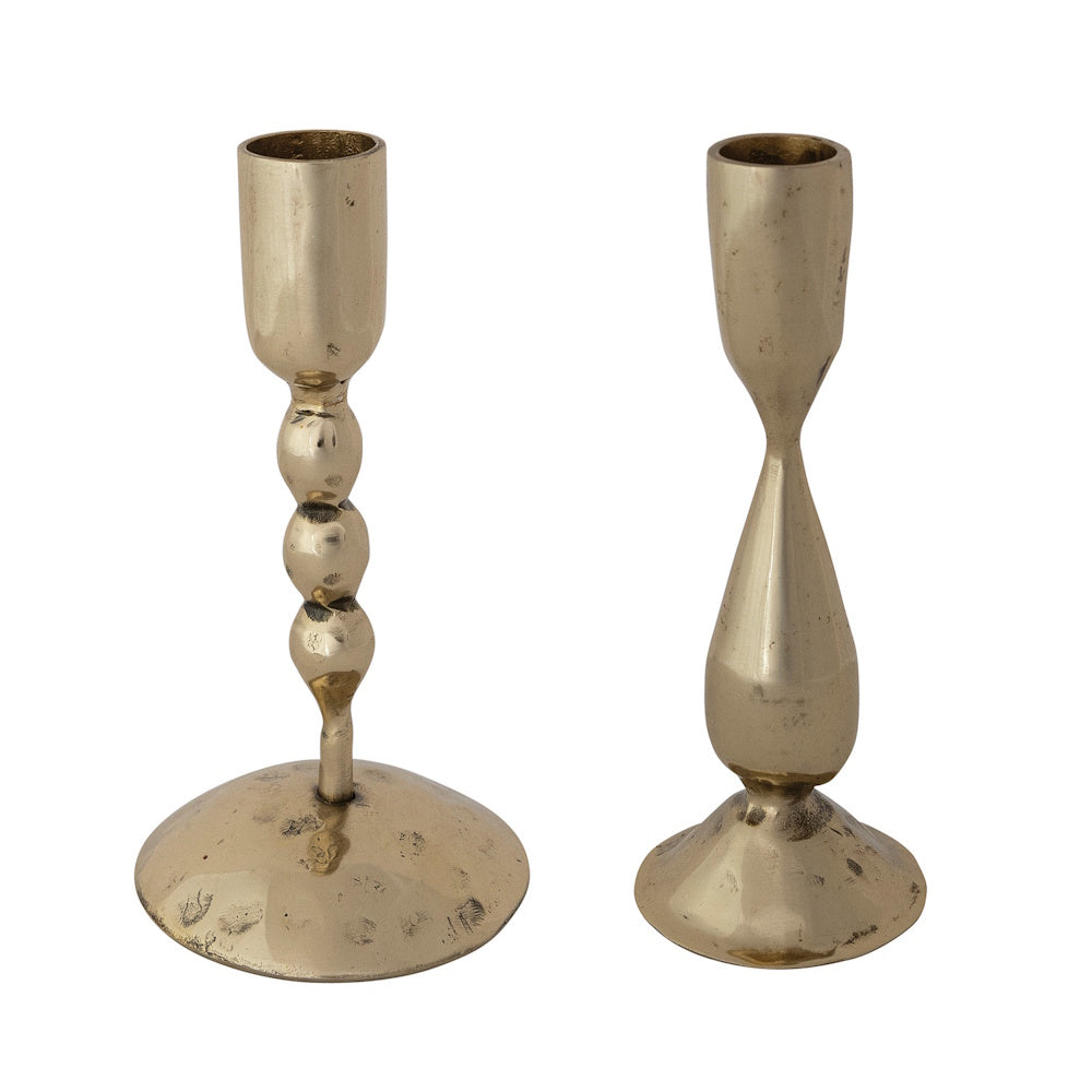 Two hand-forged brass metal taper candle holders with unique shapes.